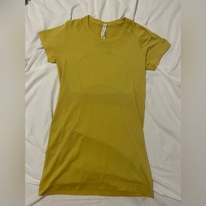 mustard yellow/ gold lululemon workout shirt. i think it’s a swiftly tech top.